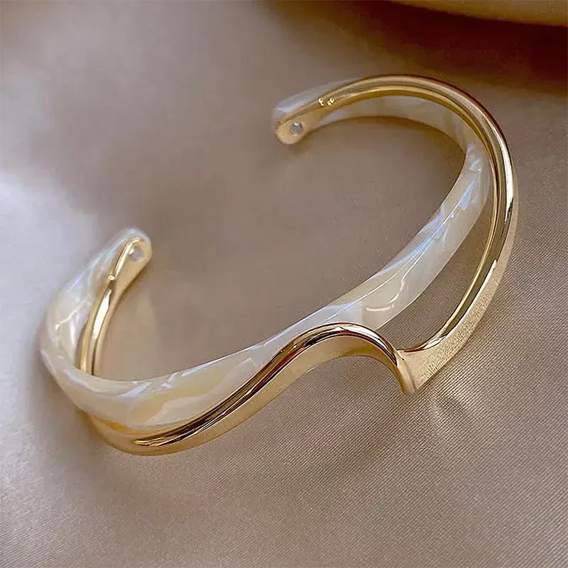 Elegant open bracelet crafted from white enamel and gold. Jula Jewelry