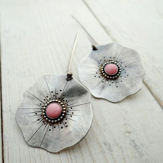 Vintage earrings featuring silver petals and a red gemstone. Jula Jewelry