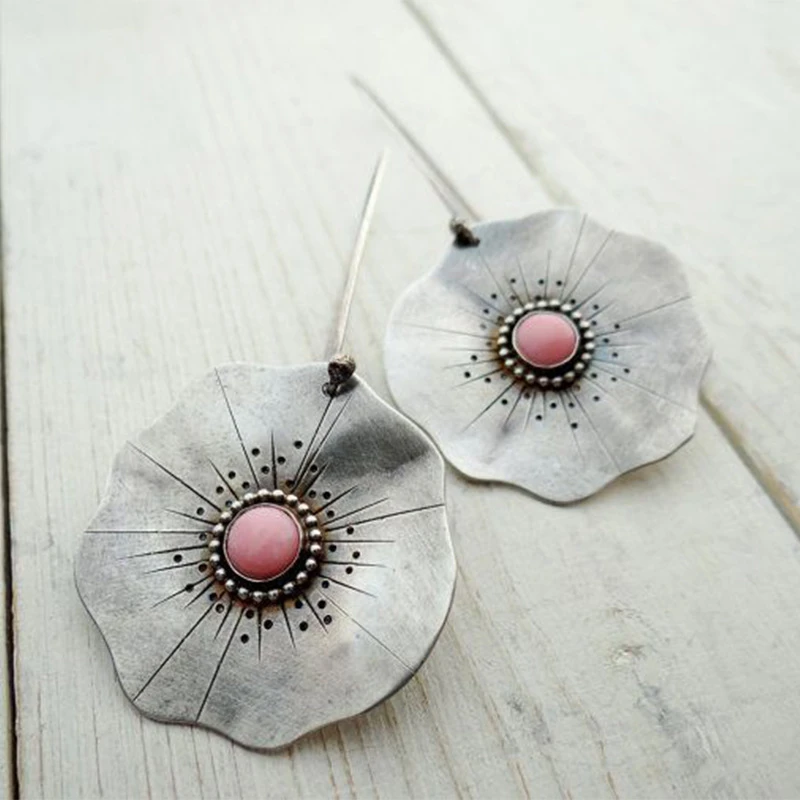 Vintage earrings featuring silver petals and a red gemstone. Jula Jewelry