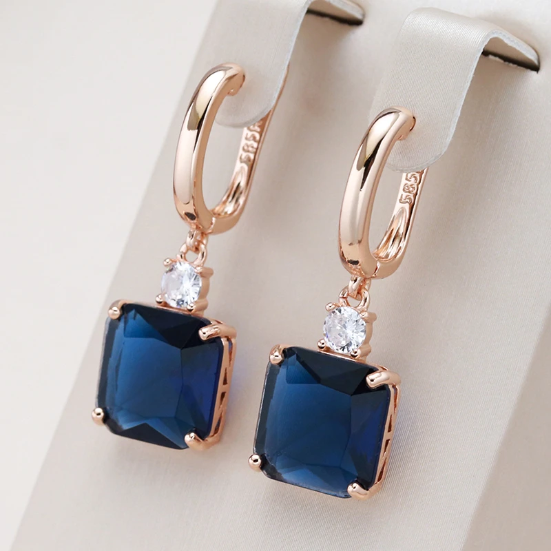 Elegant earrings featuring deep blue crystals set in gold. Jula Jewelry